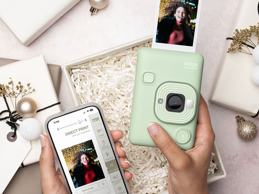 Zielony Fujifilm Instax mini LiPlay obok smartfona z aplikacją do drukowania zdjęć