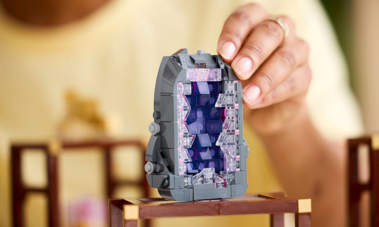 dłoń kobiety, układa kamień z klocków lego