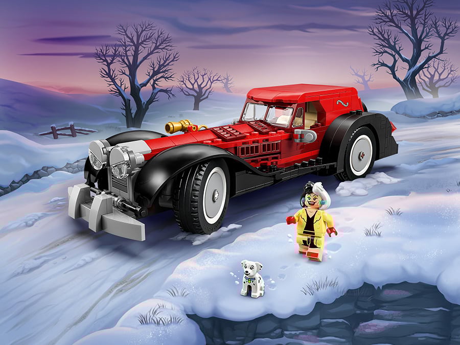 Zimowa sceneria z czerwono-czarnym samochodem LEGO inspirowanym Cruellą de Mon, figurką Cruelli w żółtym płaszczu oraz małym dalmatyńczykiem na śniegu